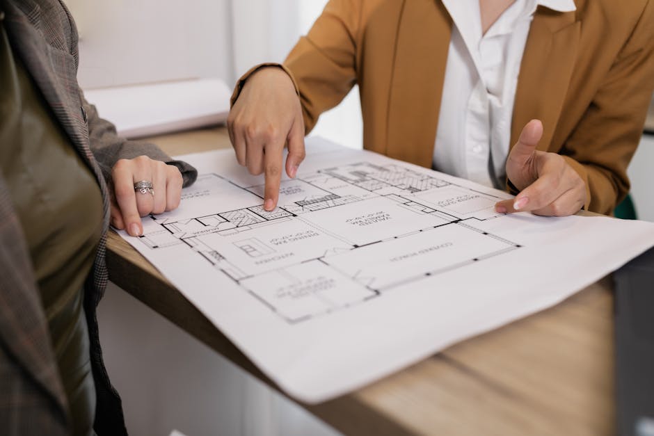 Partners Two professionals reviewing architectural plans, focused on floor layout and design details.